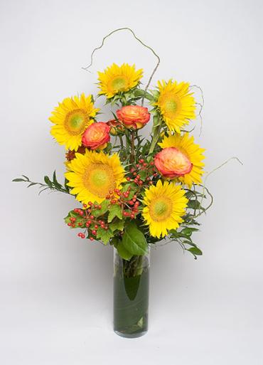 Sunflowers and roses in tall cylinder